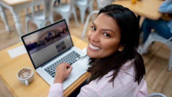 Happy woman building a website in a class