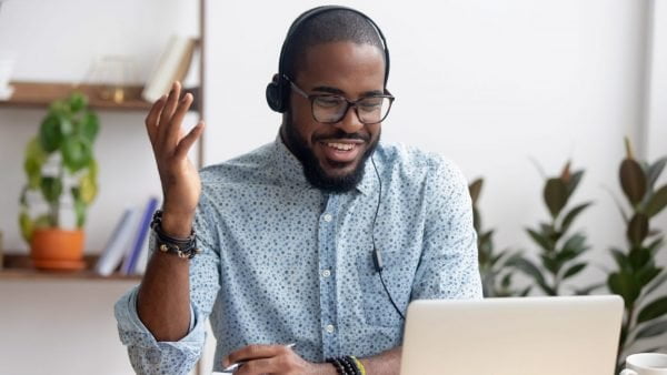 Smiling man at laptop doing webinar